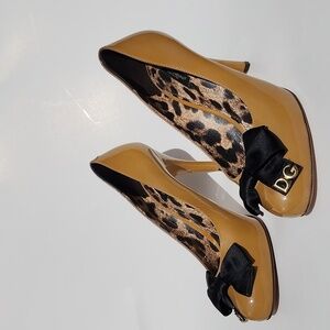 Authentic Dolce & Gabbana Mustard Patent leather with black bow heels. Size 40